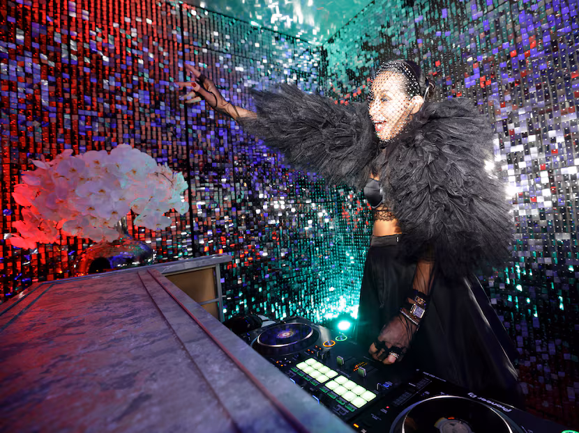 DJ RomiQ keeps the music going during cocktail hour at an amfAR event in Dallas, Texas, on...