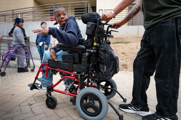 Xavier Young heads to gym class with classmates at Elliot...