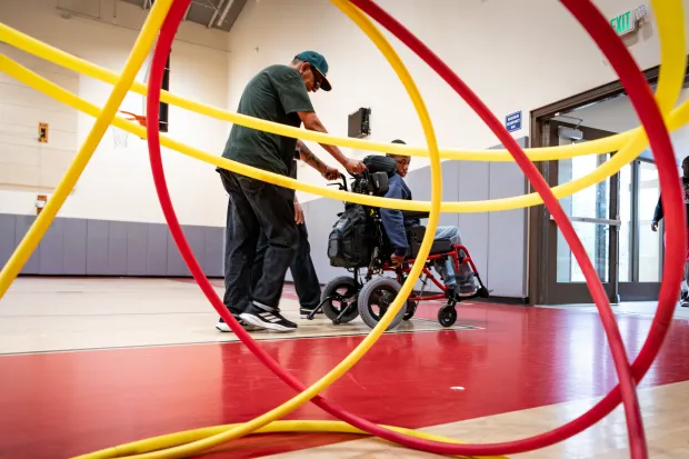 Humberto Rebollo, therapist, takes Xavier Young to his next class...