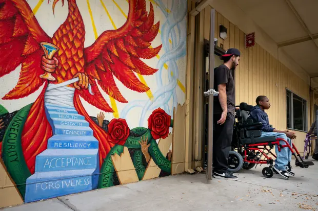 Jacob Pinedo, therapist, assists Xavier Young between classes at Elliot...