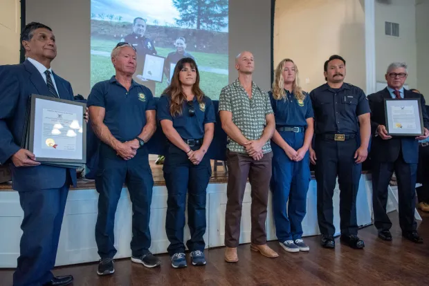 California State Parks Ocean Lifeguards Steve Ayres, Maddie Gamette, Masen Karsten, Samuel Muller and Brandon Tran receive the Heroic Act Award for their teamwork on Sept. 4, 2024 treating the cardiac arrest of an outrigger paddler in a Catalina to Newport race, providing 35 minutes of CPR on open ocean, during a California Surf Lifesaving Association ceremony at the Women's Club of Laguna Beach on Thursday, October 9, 2025. (Photo by Jeff Antenore, Contributing Photographer)