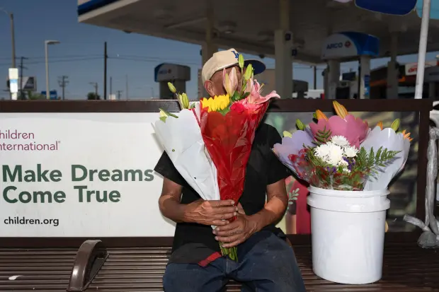 FILE – Flower vendor Jose, an immigrant from Mexico, sits...