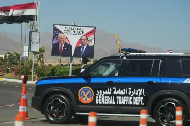A police vehicle in front of a poster showing Egyptian President Abdel-Fattah el-Sissi and U.S. President Donald Trump at the Red Sea city of Sharm el-Sheikh, Egypt