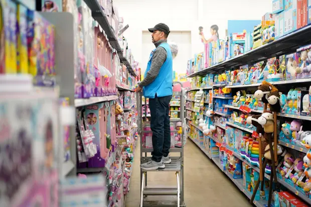 An employee stocks shelves in the toy section of a Walmart