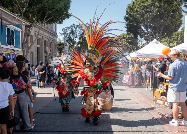 Adolfo Arteaga from Danza Azteca Xochipilli walks through the Casita...