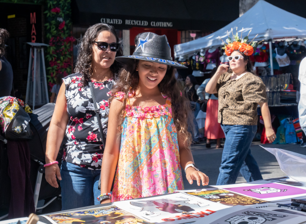 Summer Ruiz Najera looking through Lalo Alcaraz’s work during the...