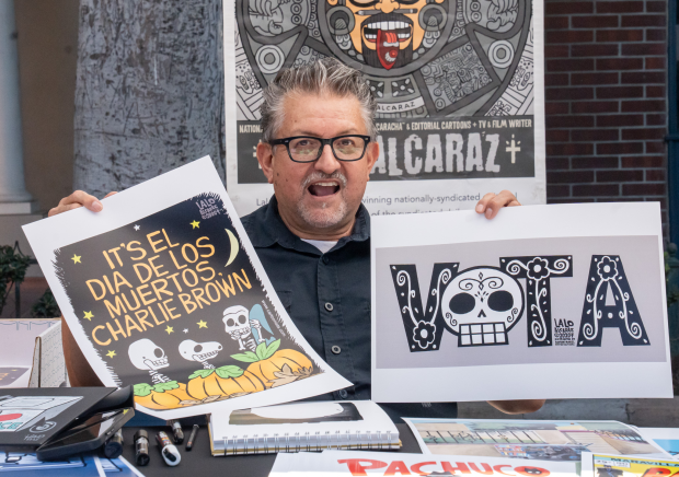 Lalo Alcaraz has his photo taken with two of his...