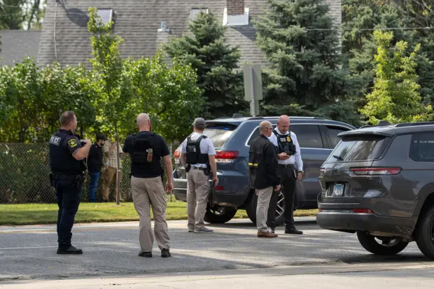 Law enforcement personnel investigate after the Department of Homeland Security said an Immigration and Customs Enforcement agent fatally shot a man in the Franklin Park suburb of Chicago on Friday, Sept. 12, 2025. (Candace Dane Chambers/Chicago Sun-Times via AP)