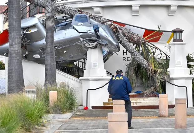 An FAA investigator at the site where a 1980 Bell...