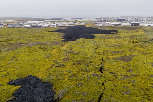 A crack cuts through an old lava field Friday, Oct. 10, 2025, near Grindavik, Iceland, as lava from eruptions in April 2025, bottom, and Jan. 14 2024, top, are visible. (AP Photo/Marco di Marco)