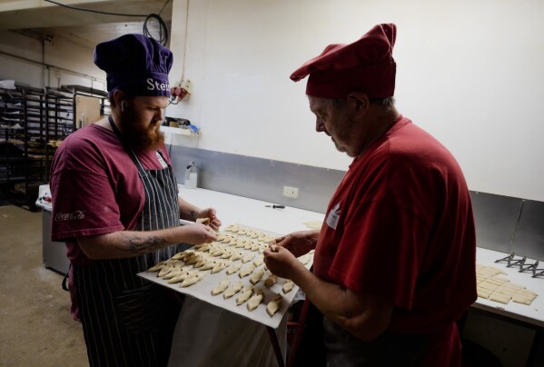 Sigurður Enoksson, right, and his son Steinþór prepare dough at Herastubbur Bakari in Grindavik, Iceland, Monday, Oct. 13, 2025. (AP Photo/Marco di Marco)