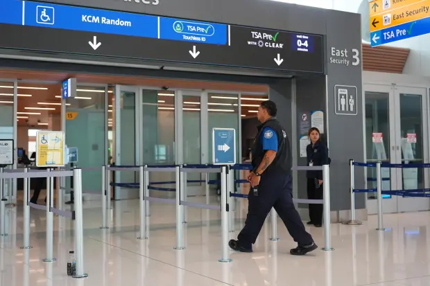 A Transportation Security Administration worker heads into the east security checkpoint in Denver International Airport