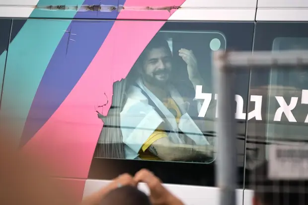 Ziv Berman, an Israeli hostage released from the Gaza Strip gestures from a minibus at the Sheba Medical Center in Ramat Gan, Israel, Monday, Oct. 13, 2025. (AP Photo/Leo Correa)