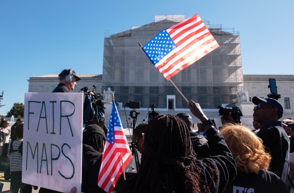 Voting rights activists gather outside the Supreme Court in Washington, early Wednesday, Oct. 15, 2025, as the justices prepare to take up a major Republican-led challenge to the Voting Rights Act, the centerpiece legislation of the Civil Rights Movement. (AP Photo/Cliff Owen)