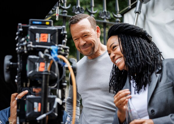 This image released by CBS shows Donnie Wahlberg, left, and Sonequa Martin-Green on location in Boston during the filming of "Boston Blue." (Michele Crowe/CBS via AP)