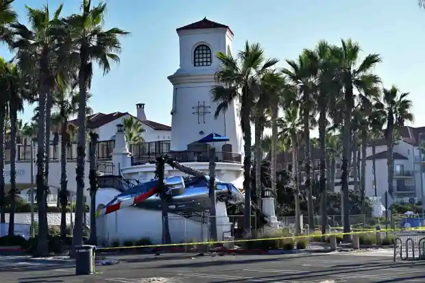 The crash site where a helicopter slammed into a stairwell of a pedestrian bridge crossing Pacific Coast Highway in Huntington Beach on Saturday. The Hyatt Regency is in the background. (Photo by Steven Georges, Contributing Photographer)