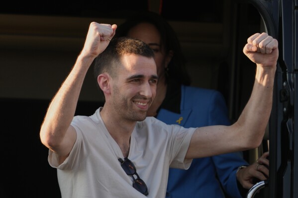 Freed Israeli hostage Avinatan Or gestures from a van as he arrives at Beilinson hospital in Petah Tikva, Israel, after he was released from Hamas captivity in the Gaza Stripl, Monday, Oct. 13, 2025. (AP Photo/Ariel Schalit)